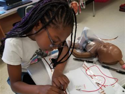 Fifth grade student from Crofton ES works on her wearable tech device for her MESA competition for creating a WT garment to detect infant respiration